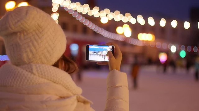 Happy Woman Taking Pictures of European Christmas Market Scene on Smartphone