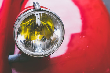 Phare et chromes d'une voiture ancienne rouge