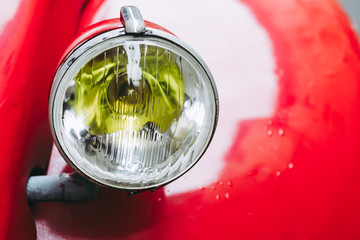 Phare et chromes d'une voiture ancienne rouge