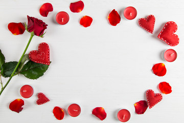 Red rose, petals, candles and hearts on the white table. An amazing surprise for a loved one on Valentine's Day. Top view, copy space.