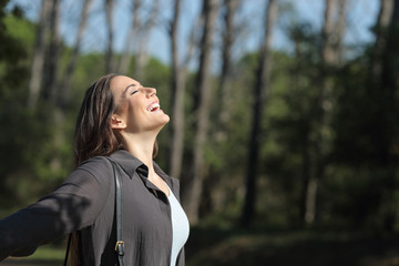 Happy woman breaths fresh air in a park