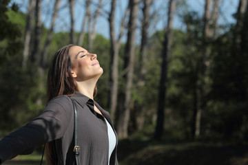 Satisfied woman breathing deeply fresh air enjoying sunshine