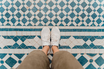 Woman's feet standing on traditionally tiled floor, Fez, Morocco