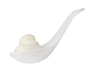 Sour cream in white spoon isolated on background. Close up.