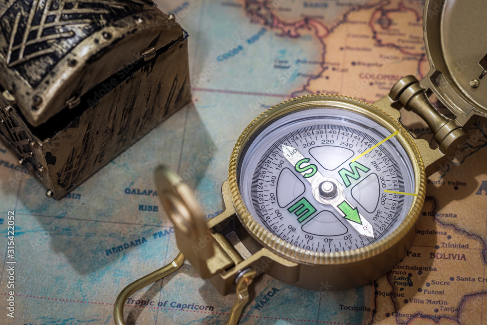 Aufkleber A fragment of an old map with a compass and an old chest in the background. The concept of searching for lost treasures or discovering secrets.  