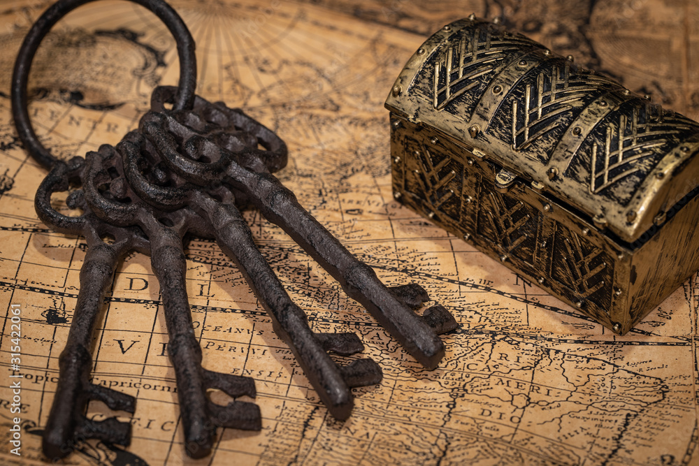 Fototapete A fragment of an old map with keys and a chest in the background. The concept of searching for lost treasure. Discovering secrets and opening closed places