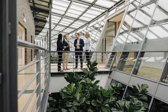 Business people standing on a skywalk in modern office building