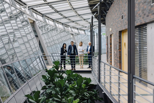 Business people standing on skywalk in modern office building