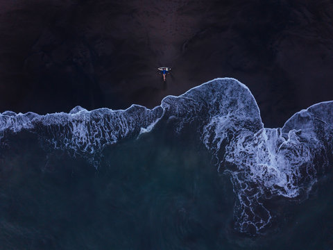Aerial view of young woman with surfboard at the beach, Kedungu beach, Bali, Indonesia
