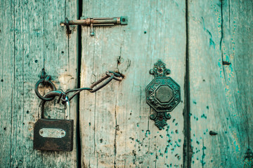 Old wooden door with handle, heck and lock. Boho style.