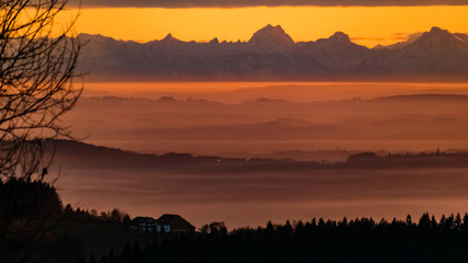 Beautiful sunset with the distant alps in the background near Daxstein, Bavarian forest, Bavaria, Germany