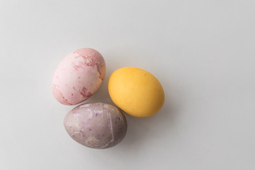 painted eggs on a light background in a blue nest