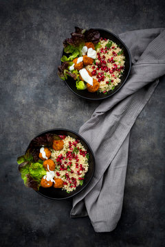 Bowls of falafel with lettuce, yogurt, pomegranate seeds, parsley, mint and Tabbouleh salad