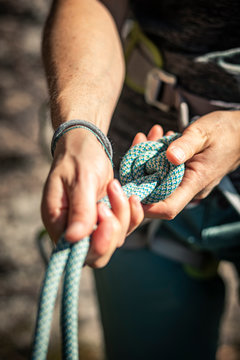 Woman preparing to climb, checking rope