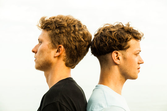 Portrait of strawberry blonde young men, back to back