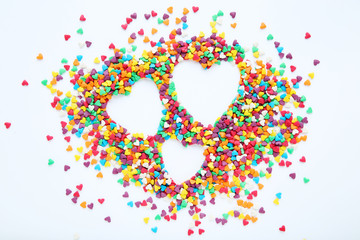 Colorful heart shaped sprinkles on white background
