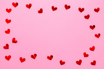 Red paper hearts confetti frame on pink background