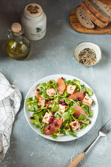 Healthy eating, grilled salmon, arugula, grapefruit and pomegranate on gray table, top view