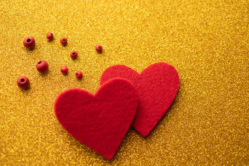Red felt hearts on golden shiny background. Valentine's Day