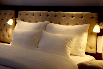 Bed made-up with white big pillows at beautiful bedroom. Beautiful pillow on bed decoration in...