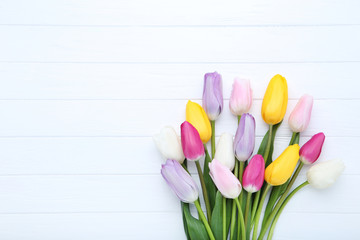 Fototapeta premium Bouquet of tulip flowers on white wooden table