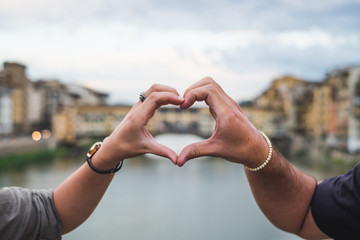 Young couple hands united in a heart shape. Florence Italy - obrazy, fototapety, plakaty