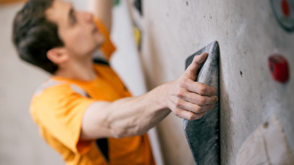 Mann beim Bouldern an Kletterwand