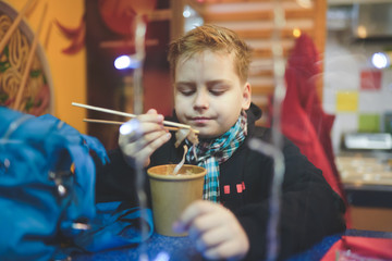 Boy eating in noodle shop