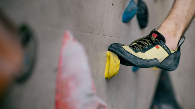 Mann beim Bouldern an Kletterwand