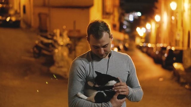 Cat. A man stroking a yard cat. Italy. Terracina.