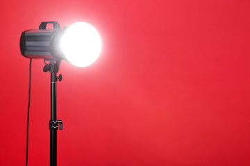 Studio lighting with tripod on red background