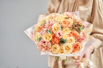 European floral shop. Beautiful bouquet of mixed flowers in womans hands. the work of the florist at a flower shop. Delivery fresh cut flower.