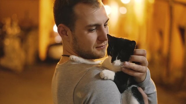 Cat. A man stroking a yard cat. Italy. Terracina.