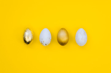 Premium gold Set of 4 Easter eggs isolated on yellow background Ester concept. Top view