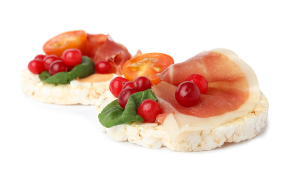 Puffed rice cakes with prosciutto, berries and tomato isolated on white