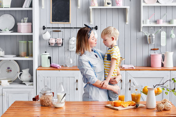 Mother and Sad boy in kitchen. Bright morning in the kitchen. Healthy Breakfast cereals and fresh fruit.