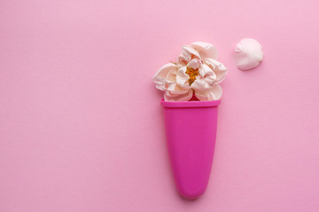 Rose Bud and delicate petals in an ice cream mold on a pink background. Space for text. Flower arrangement