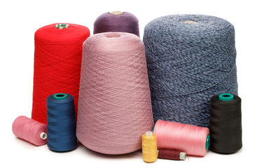 Cones and spools of color threads on white background