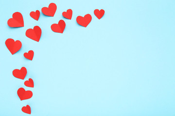 Red paper hearts on blue background
