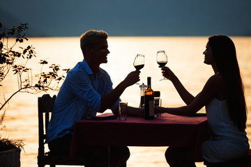 Happy couple on summer evening having romantic dinner outdoor