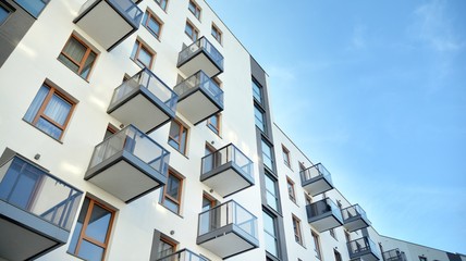 Contemporary residential building exterior in the daylight. Modern apartment buildings on a sunny day with a blue sky. Facade of a modern apartment building