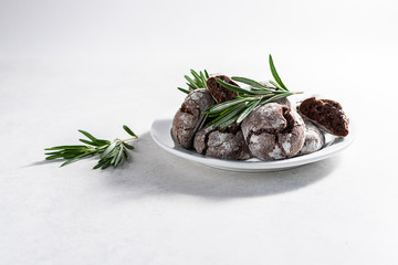 Fresh homemade chocolate cookies with rosemary on white background with copy space for your design. Tasty homemade dessert.