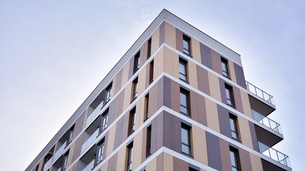 Contemporary residential building exterior in the daylight. Modern apartment buildings on a sunny day with a blue sky. Facade of a modern apartment building