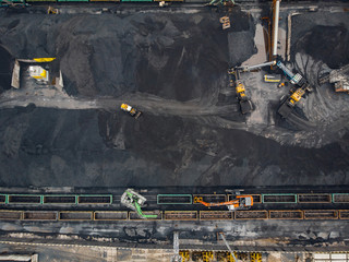 Loading coal anthracite mining in port on cargo tanker ship with crane bucket of train. Aerial top...