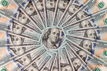 Close-up of cash one hundred american dollars as a circle, in the center of flat lay composition is a portrait of president Franklin, concept of business and finance, top view