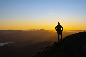 man on top of the mountain at sunrise backlit, Aiako Harriak Nature Park, Euskadi