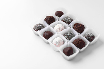 Ball-shaped chocolate candies packed in small paper baskets isolated on white background. Tasty dessert. Homemade sweet. Minimal style.