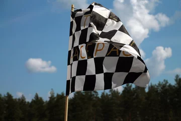  A checkered flag waving in the wind of a Formula 1 race © Mattias