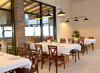 Restaurant interior with tables for six and pendant lights