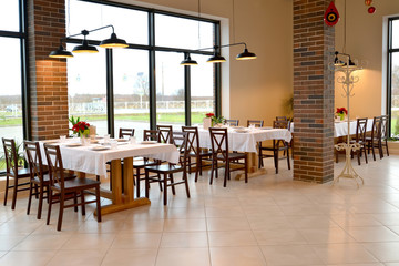Restaurant interior with tables for six and pendant lights